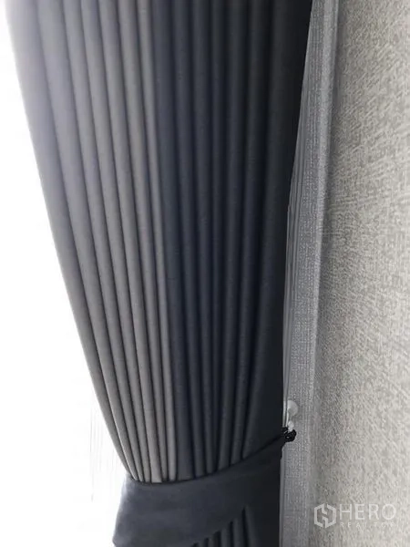 Condominium for rent in Khlong Toei, Bangkok - Close-up of dark gray pleated blackout curtains.