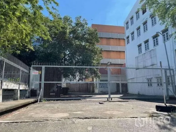 Factory for rent in Phra Samut Chedi, Samut Prakan - Wide driveway and sliding metal gate between white and orange factory buildings.