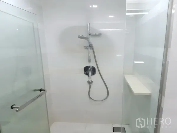 Condominium for rent in Khlong Toei, Bangkok - Glass-enclosed shower with handheld and rain shower fixtures.