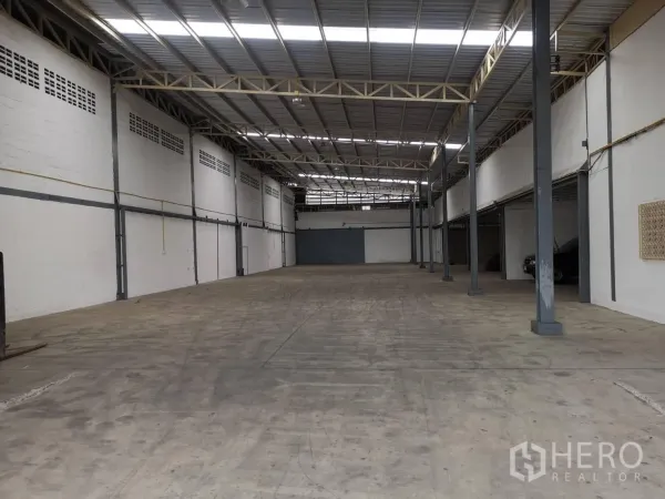 货栈 出租在Suan Luang, Bangkok - 宽阔通跨仓库大厅，立柱排布与大面积混凝土装卸空间。
