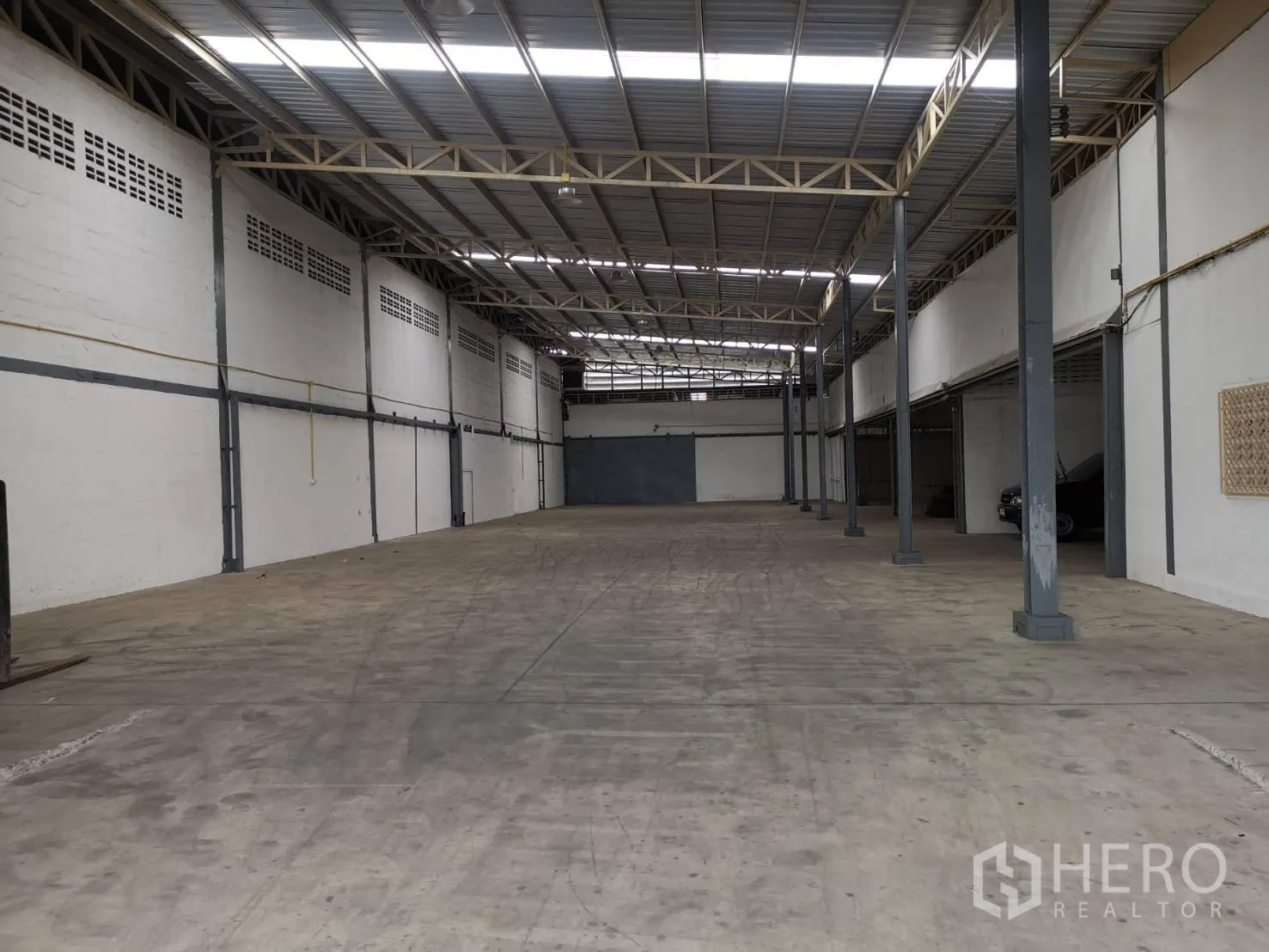 货栈 出租在Suan Luang, Bangkok - 宽阔通跨仓库大厅，立柱排布与大面积混凝土装卸空间。