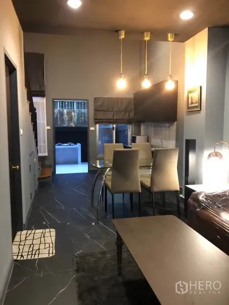 Townhouse for rent in Bang Kapi, Bangkok - View toward the dining space and kitchen with three pendant lights and dark tile flooring.