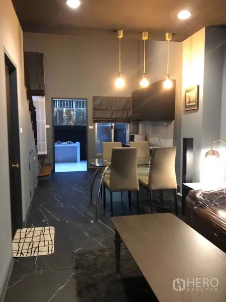 Townhouse for rent in Bang Kapi, Bangkok - View toward the dining space and kitchen with three pendant lights and dark tile flooring.