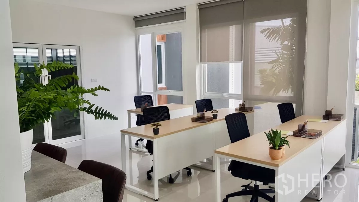 Warehouse for sale in Lam Luk Ka, Pathum Thani - Light-filled workspace with desks, swivel chairs and indoor plants.