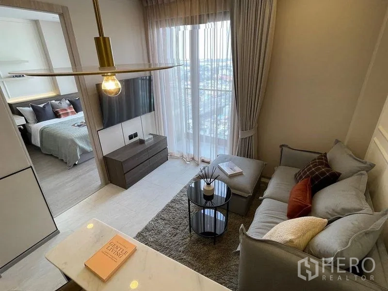 Condominium for rent in Pathum Wan, Bangkok - View from kitchen toward living room and bedroom entrance with city-view windows.