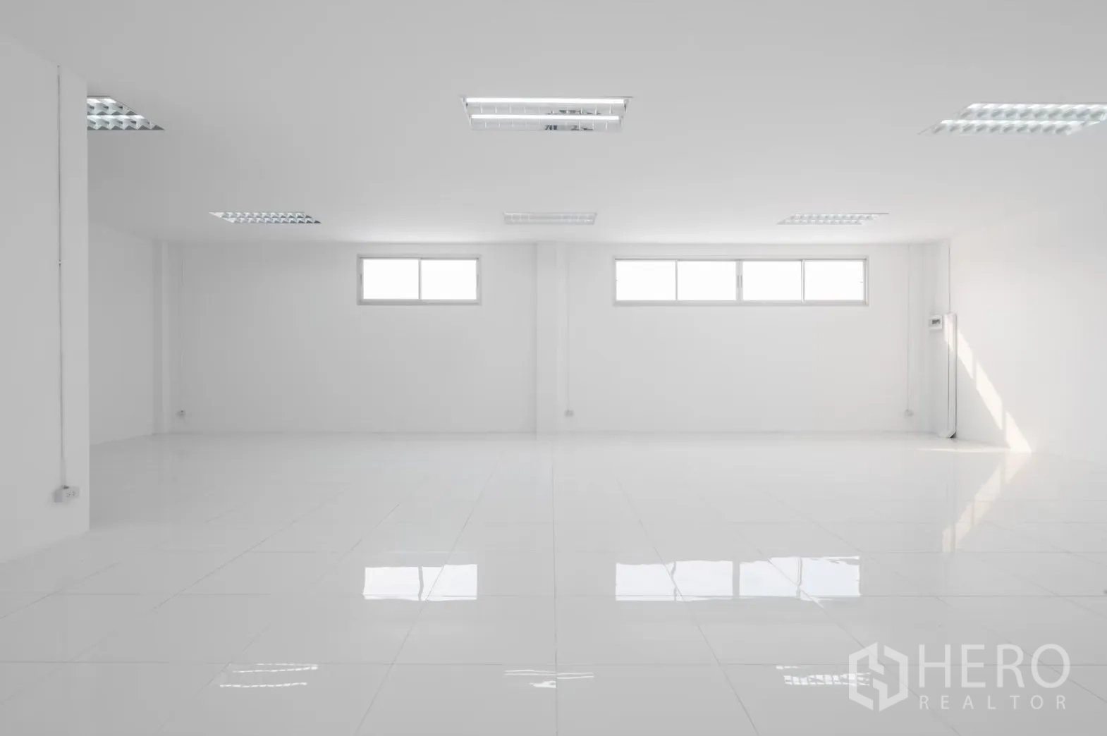 工厂 出租在Pathum Thani - 开阔白色办公空间，三扇横窗，亮面地砖。