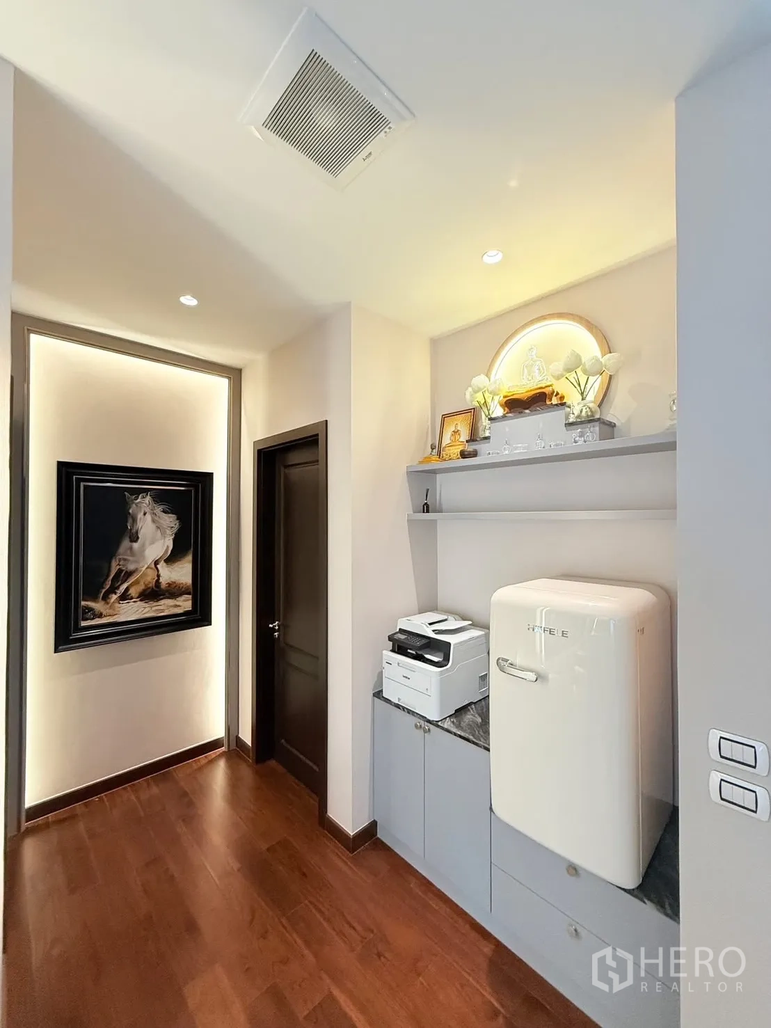 Detached House for rent or sale in Bang Phli, Samut Prakan - Upstairs hallway with built-in cabinetry, compact fridge, printer, wood flooring and recessed lighting.