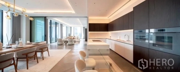 Condominium for rent or sale in Pathum Wan, Bangkok - Open-plan gourmet kitchen with marble island, dark wood cabinetry and a dining area beside floor-to-ceiling windows with city views.