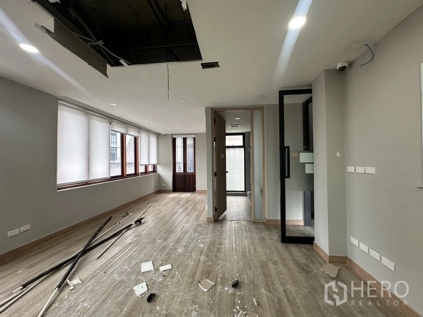 Home Office for rent in Pathum Wan, Bangkok - Long room with corridor, bathroom access and wood flooring undergoing light renovation.