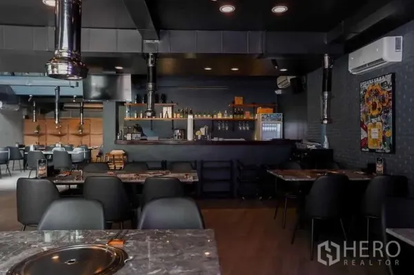 Detached House for rent in Watthana, Bangkok - Open-plan dining space with bar counter, marble tables, ceiling ducting and recessed lighting.