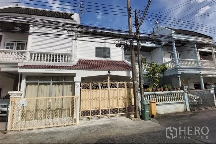 Townhouse for sale - Two-storey townhouse exterior with gated carport in Bang Chak near BTS.