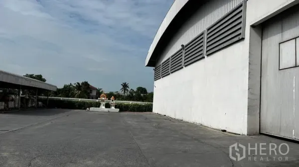 Factory for rent or sale in Pathum Thani - Expansive concrete yard beside the factory building with side loading access.