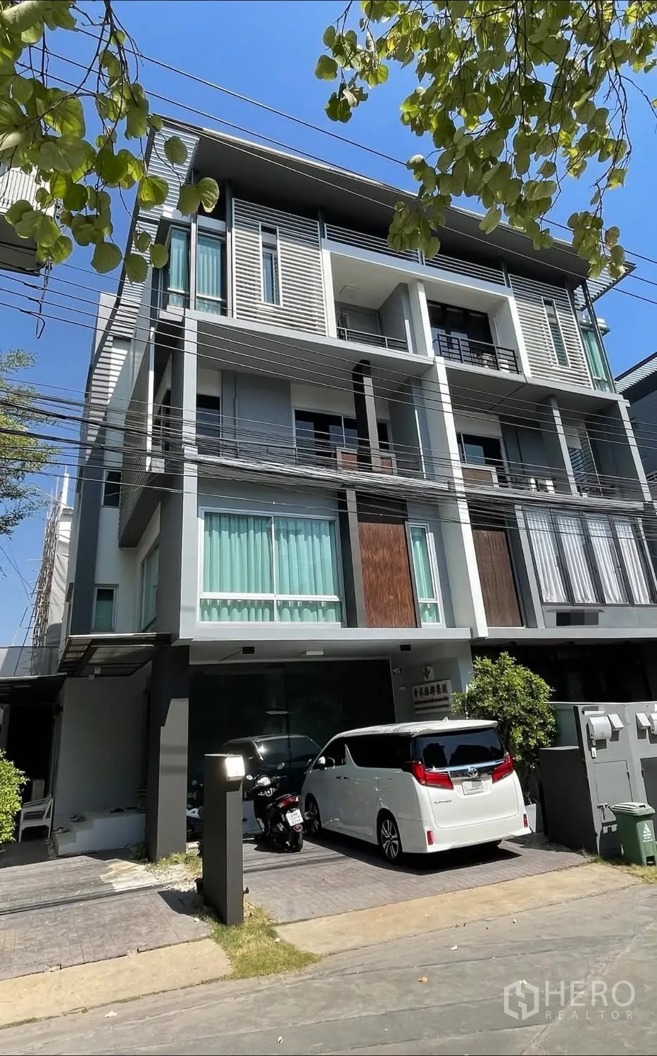 Home Office for rent or sale in Wang Thonglang, Bangkok - Exterior view of the home office building with parking in front.