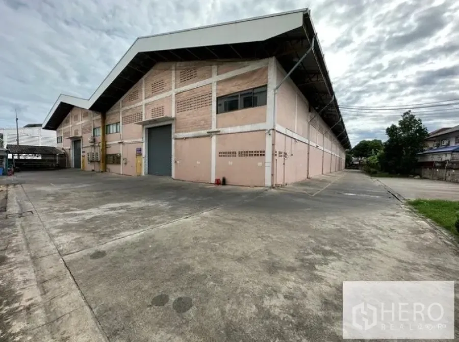 Warehouse for rent in Sam Phran, Nakhon Pathom - Corner exterior of the warehouse with wide concrete yard and easy truck access.