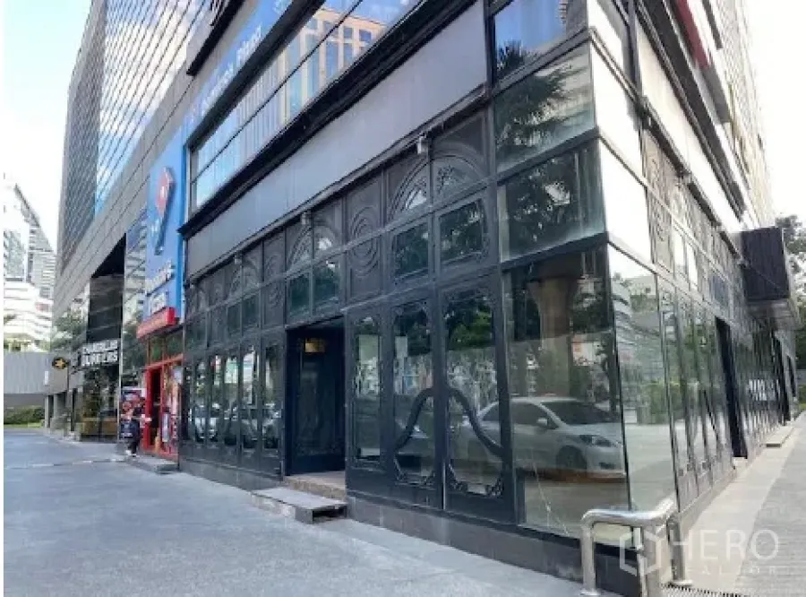 Retail Space for rent in Khlong Toei, Bangkok - Corner retail unit with floor-to-ceiling glass facade and a wide sidewalk in central Bangkok.