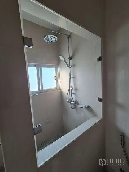 Detached House for rent in Bang Kruai, Nonthaburi - Close-up of tiled shower featuring rainfall and handheld showerheads beside a window.
