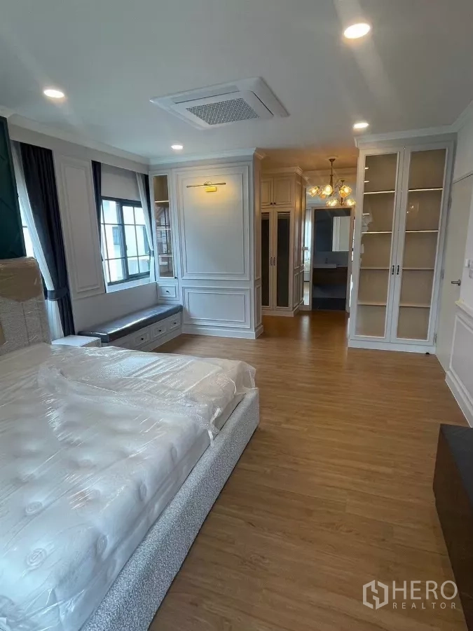 Detached House for rent in Bang Phli, Samut Prakan - Spacious master bedroom with built-in wardrobes and glass display cabinets.