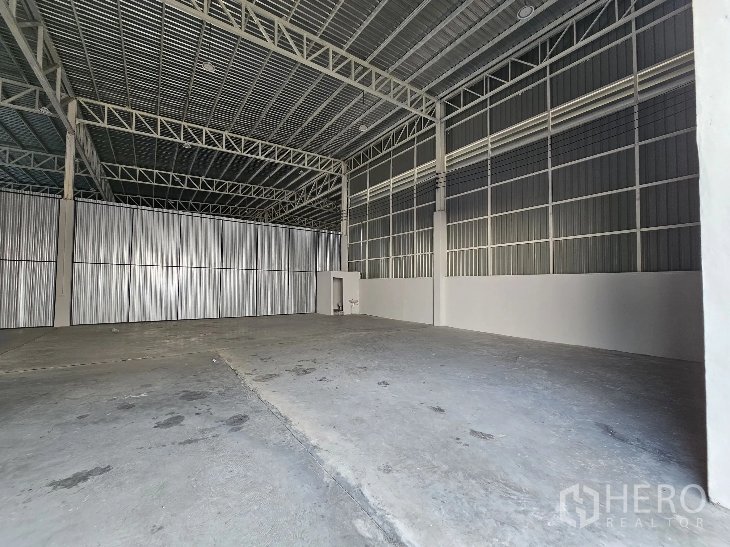 Warehouse for rent in Khlong Toei, Bangkok - Spacious warehouse bay with partition wall and metal framing.