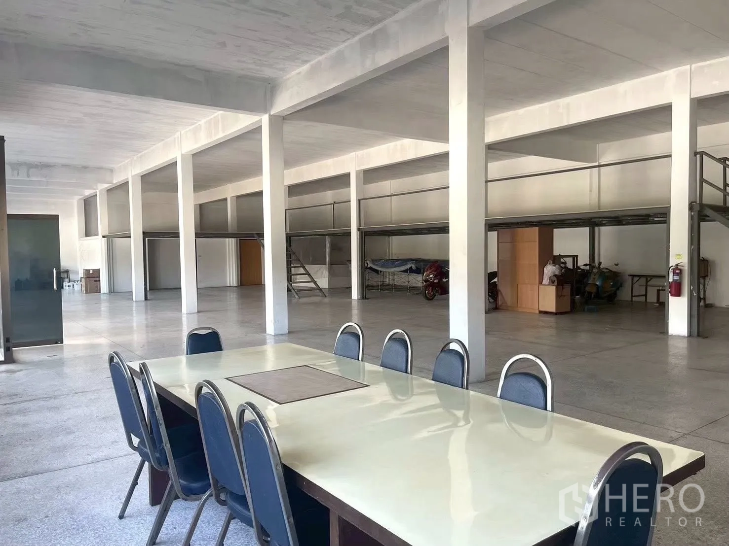 Factory for sale in Lat Krabang, Bangkok - Large open hall with mezzanine platforms and a conference table in the foreground.