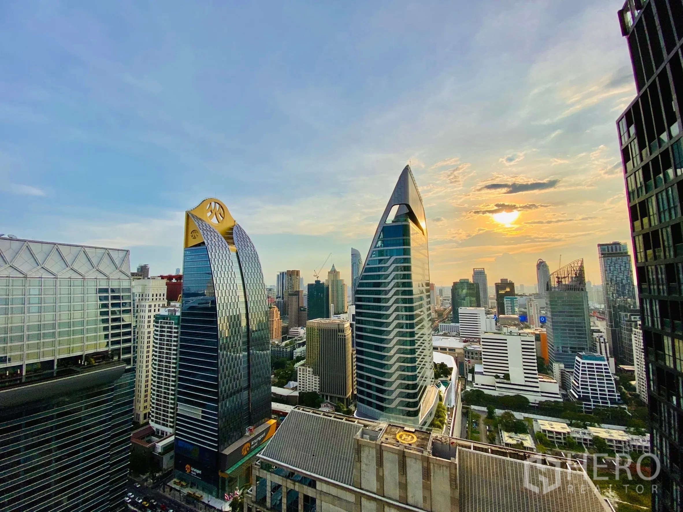 Condominium for rent in Pathum Wan, Bangkok - High-rise cityscape at sunset viewed from the condo balcony.