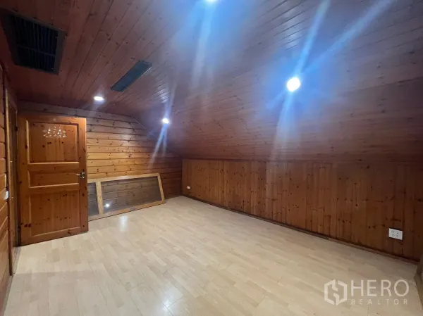 Home Office for rent in Suan Luang, Bangkok - Spacious attic-style room with timber walls, a door and ceiling downlights.