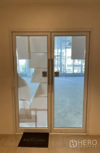 Office Space for rent in Khlong Toei, Bangkok - Glass double-door entry to the office suite with pull handles and welcome mat.