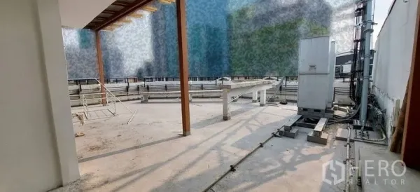 Retail Space for rent - Rooftop service area with concrete floor, utility equipment and shade beams.
