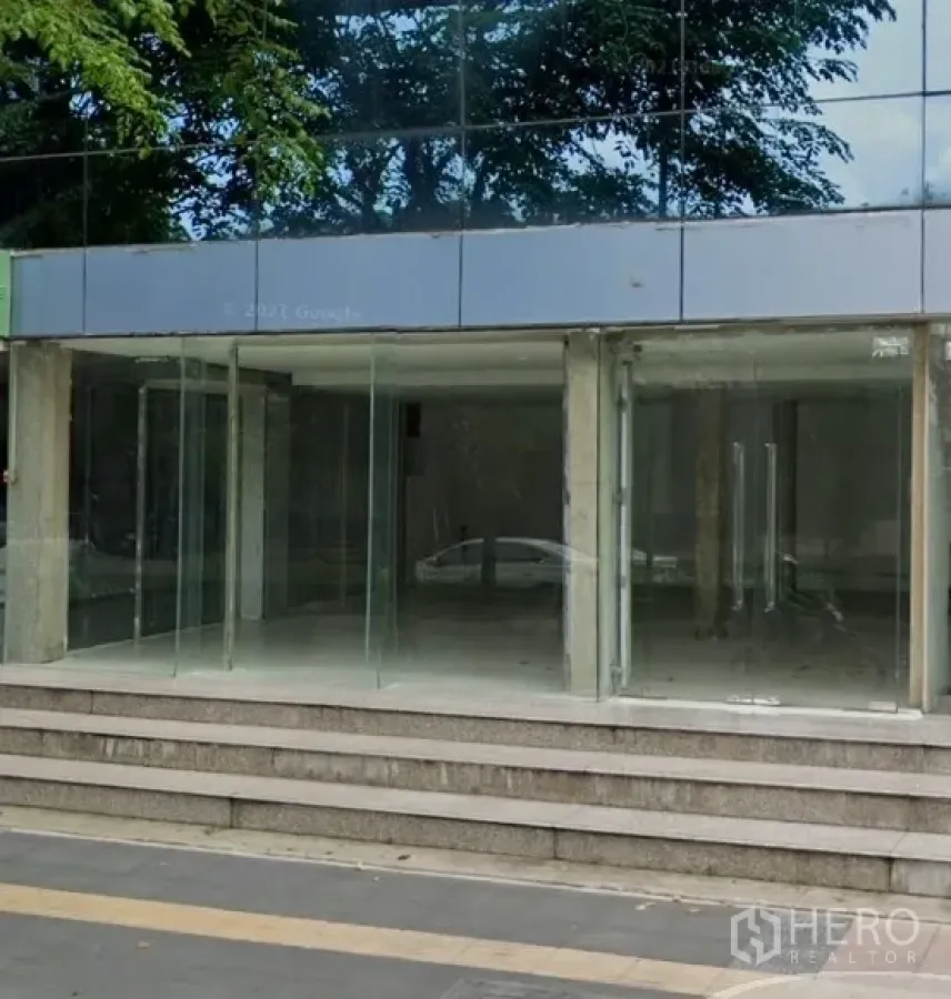 Retail Space for rent in Phaya Thai, Bangkok - Street-level glass entrance to a commercial building with steps and tree reflections.