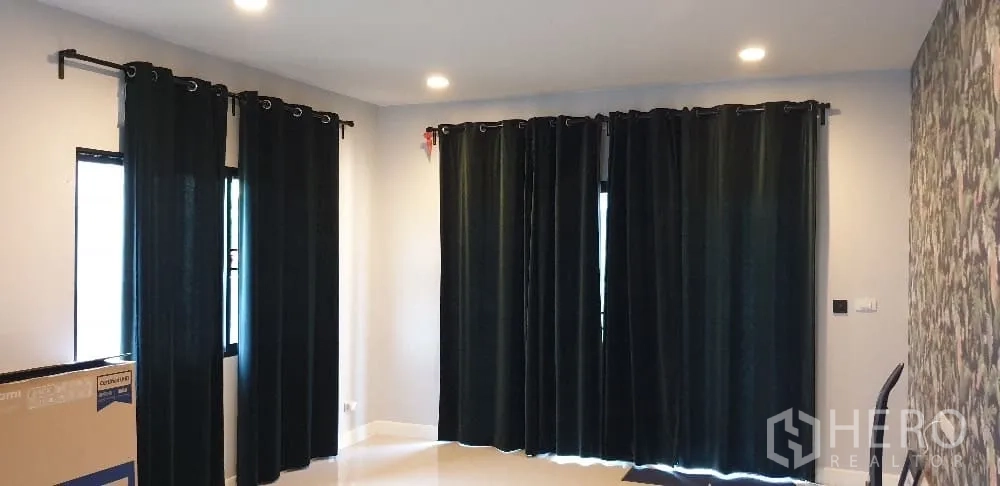 Detached House for rent or sale in Lam Luk Ka, Pathum Thani - Lounge with full blackout curtains, recessed lighting and patterned feature wall.