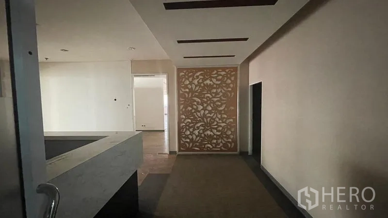 办公空间 出租或出售 - 入口前厅，雕花装饰墙、石材前台与嵌入式顶灯。