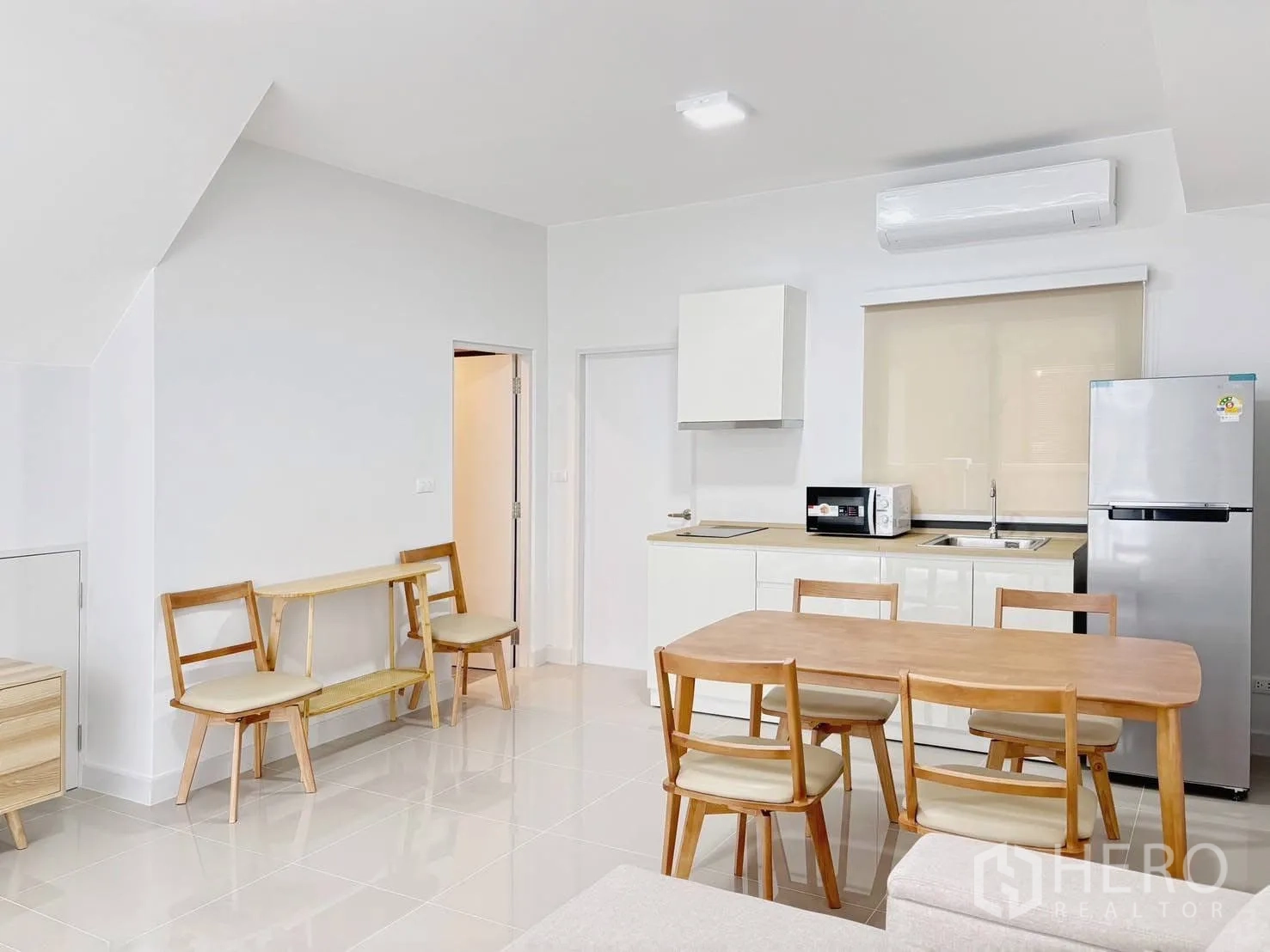 Townhouse for rent in Bang Phli, Samut Prakan - Spacious ground floor view of living, dining, and kitchen with glossy tiled floors.