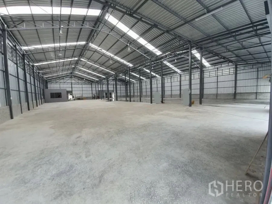 Warehouse for rent in Sai Mai, Bangkok - Spacious high-ceiling steel-frame warehouse in Sai Mai, Bangkok with concrete floor, skylight roof panels, and a built-in office room.
