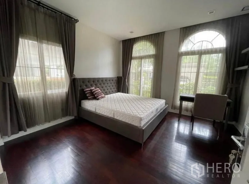 独立式住宅 出租在Bang Phli, Samut Prakan - 明亮次卧，拱形窗、木地板与书写桌。