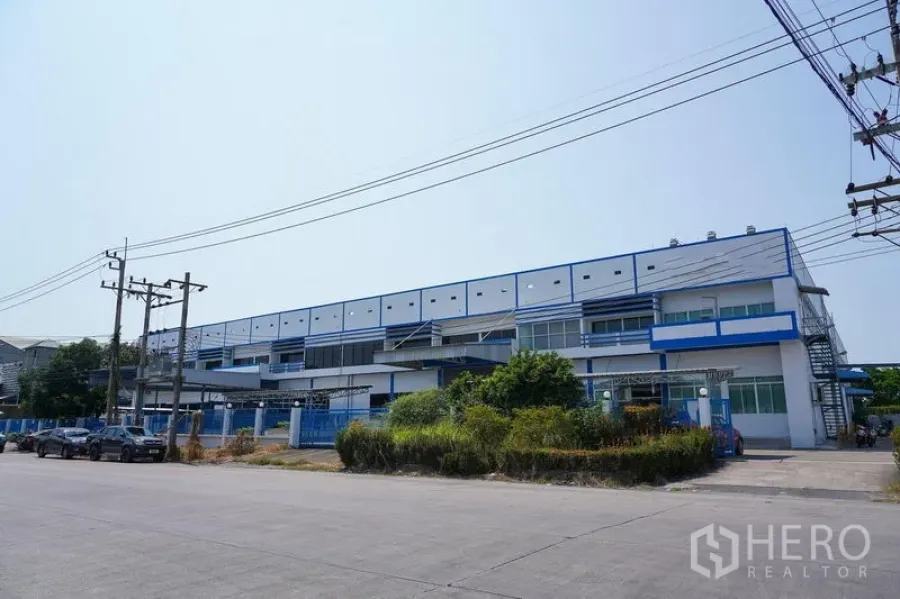Factory for rent in Bang Sao Thong, Samut Prakan - Street view of a modern blue‑and‑white industrial complex.