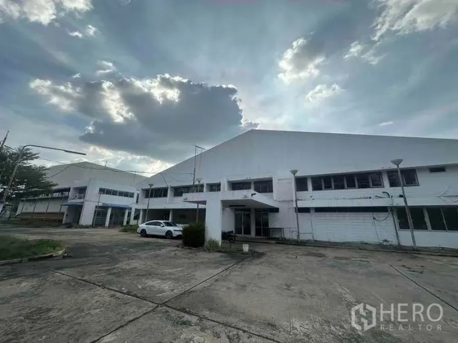 Factory for rent in Khlong Luang, Pathum Thani - Front façade of the factory complex with a wide concrete forecourt