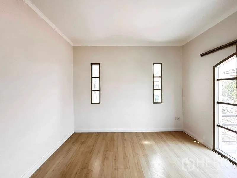 Detached House for rent or sale - Empty room with light wood flooring and slim vertical windows for natural light.