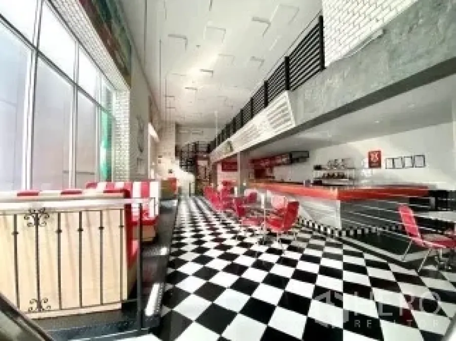 Retail Space for rent in Watthana, Bangkok - Bright retail interior with black-and-white checkered floor, long red bar seating, high ceiling and tall windows.