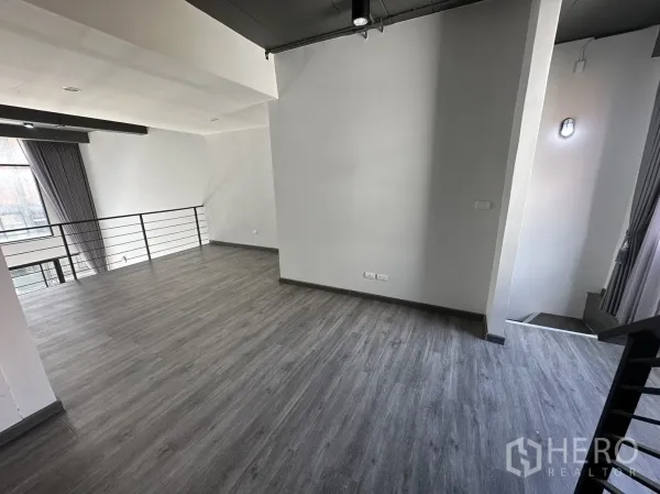 Home Office for rent or sale in Suan Luang, Bangkok - Spacious mezzanine level with grey wood floors, steel railing and a large window.