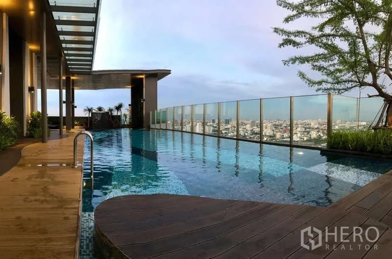 Condominium for rent in Khlong Toei, Bangkok - Another angle of the rooftop pool with wooden deck and panoramic Bangkok views.