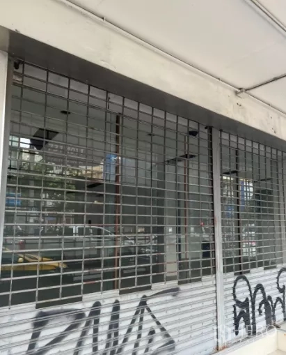 Shophouse for rent or sale in Khlong Toei, Bangkok - Street-level storefront with metal roller shutters and security grilles.