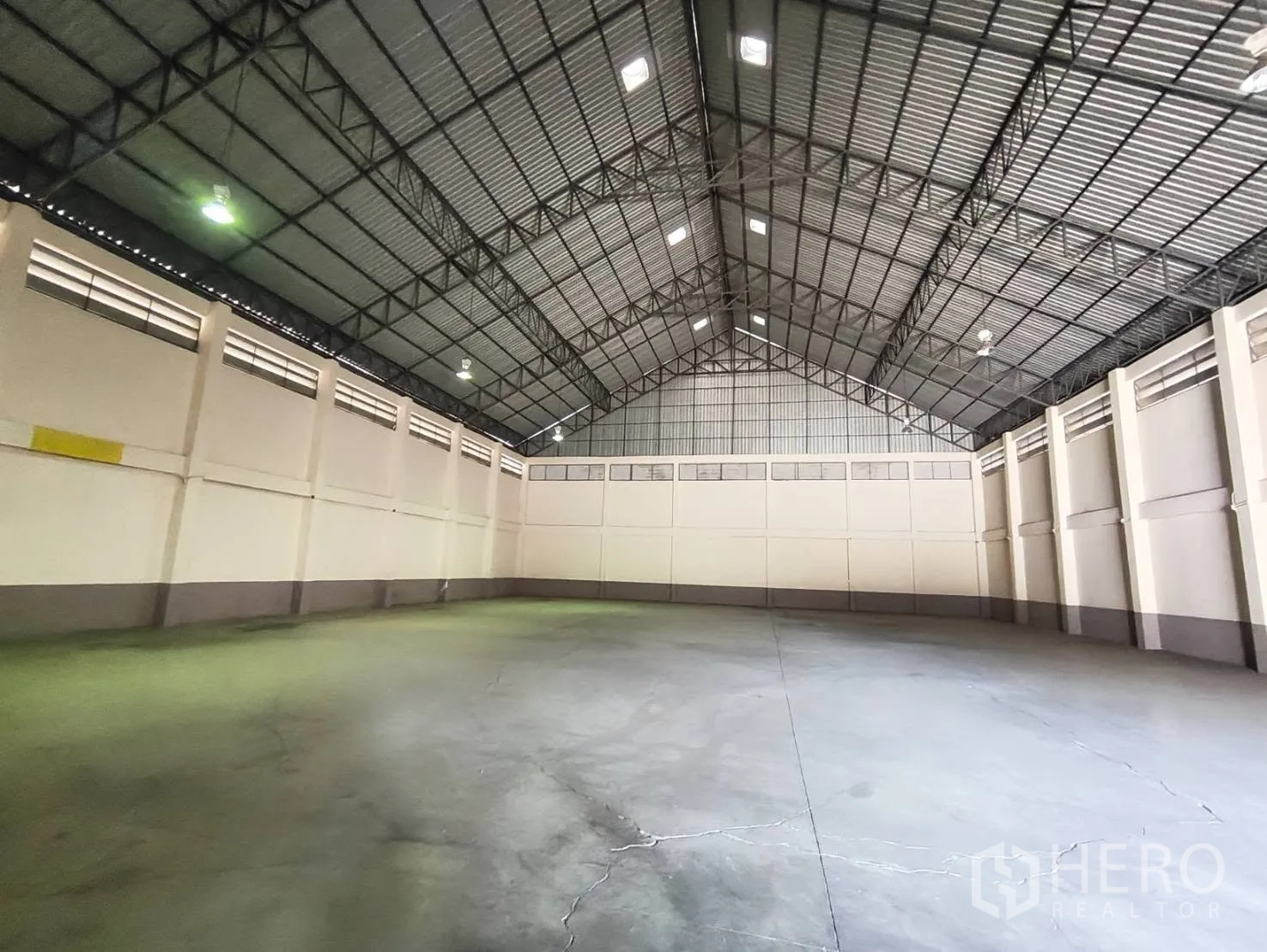 Factory for rent in Krathum Baen, Samut Sakhon - Spacious warehouse interior with a high steel truss roof and polished concrete floor.