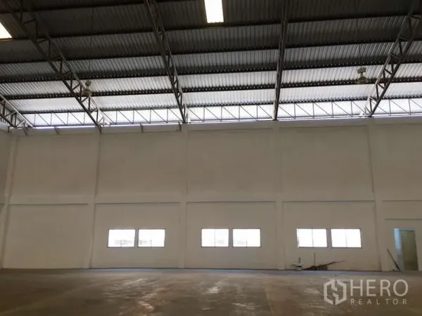 工厂 出租在Bang Bo, Samut Prakan - 厂房内部空间宽敞，挑高墙面，采光窗与混凝土地面。