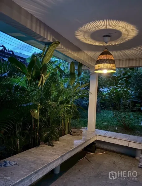 Detached House for rent in Watthana, Bangkok - Covered terrace with woven pendant light, marble bench seating and tropical garden.