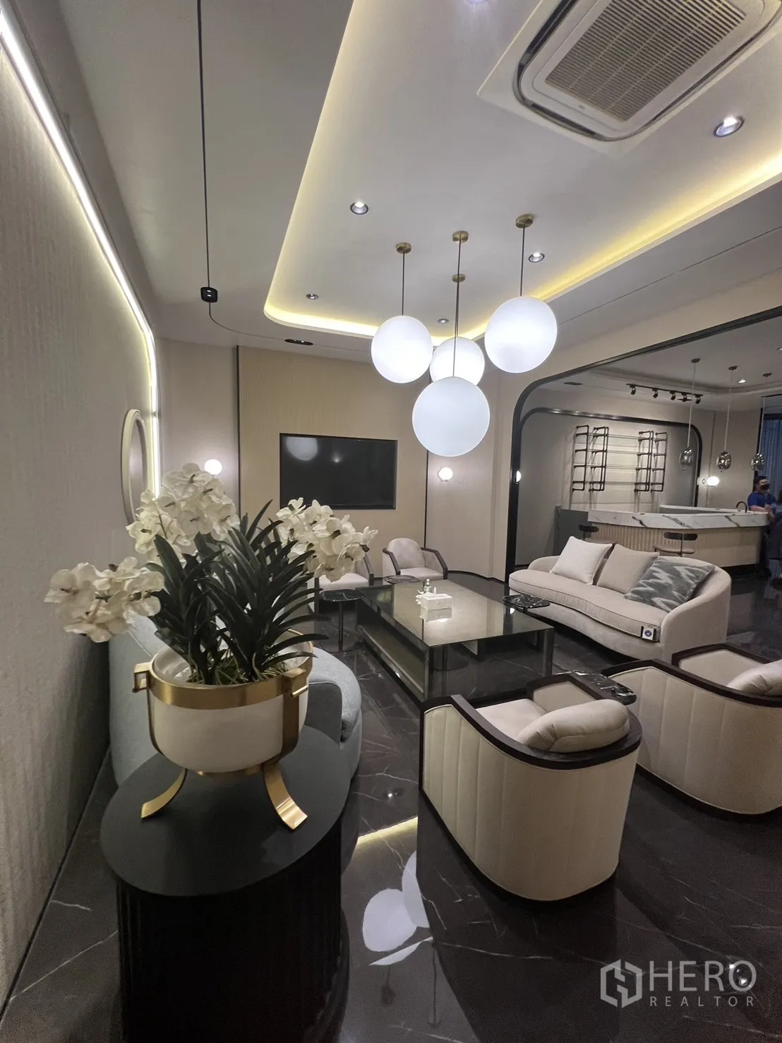 Retail Space for rent - Lounge zone with sofas, armchairs, globe pendant lighting and a cove-lit ceiling.