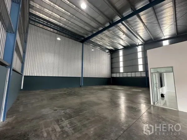 Factory for rent in Bang Phli, Samut Prakan - Spacious high-clear factory interior with steel structure, polished concrete floor and a glass-door office.