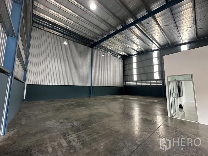 Factory for rent in Bang Phli, Samut Prakan - Spacious high-clear factory interior with steel structure, polished concrete floor and a glass-door office.