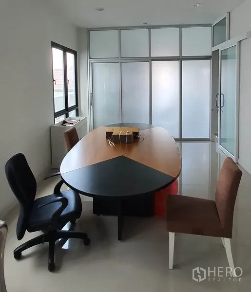 Home Office for rent in Chatuchak, Bangkok - Meeting room with oval table and frosted glass partitions.