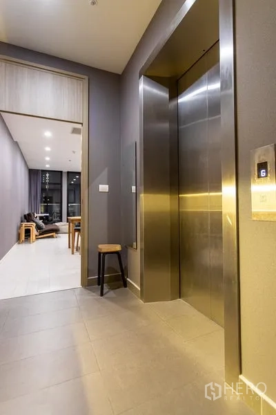 Condominium for rent in Pathum Wan, Bangkok - Condominium corridor with stainless-steel elevator next to the unit entrance