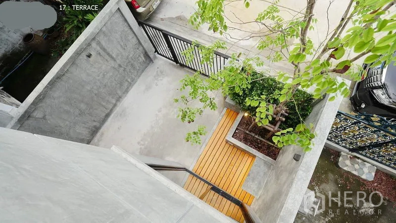 联排别墅 出租在Huai Khwang, Bangkok - 俯瞰带门车位和前院平台，有树与木质露台。