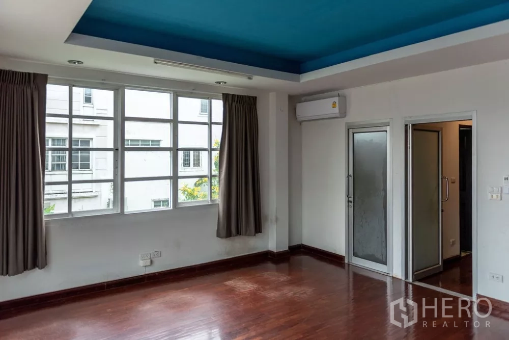 Home Office for rent in Lat Phrao, Bangkok - Room with windows, air-conditioning, and doors to a bathroom and adjacent room.